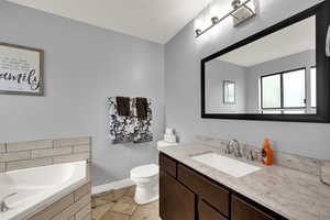 Bathroom with vanity, a bath, and light tile patterned floors