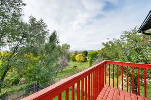 Deck featuring a fenced backyard and view of scattered trees
