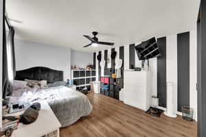 Bedroom with wood finished floors and baseboards