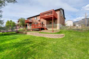 Rear view of house featuring a trampoline and a deck