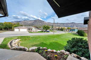 View of grassy yard with a mountain view and a residential view
