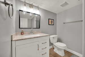 Bathroom featuring vanity, light tile patterned floors, and a textured ceiling