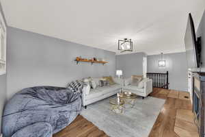 Living room featuring light wood-style floors and a chandelier