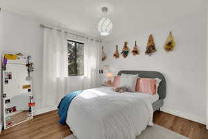 Bedroom with wood finished floors and baseboards