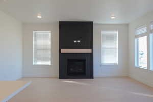 Unfurnished living room featuring a fireplace, light wood-type flooring, and recessed lighting