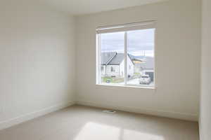 Carpeted empty room featuring baseboards