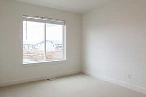 Carpeted empty room with baseboards and a residential view