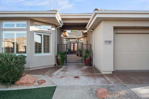 Entrance to property featuring a gate, stucco siding, and a garage