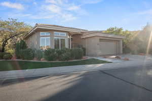 View of front facade featuring stucco siding, driveway, and a garage
