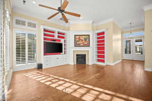 Unfurnished living room featuring healthy amount of natural light, crown molding, light wood finished floors, a tile fireplace, and recessed lighting