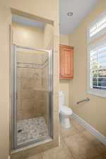 Full bath with a stall shower and light tile patterned flooring