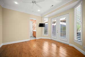 Unfurnished room featuring french doors, ornamental molding, light wood-style floors, ceiling fan, and recessed lighting