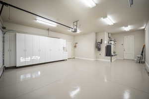 Garage with a central vacuum unit and baseboards
