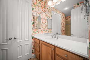 Bathroom with vanity, tile patterned floors, and wallpapered walls