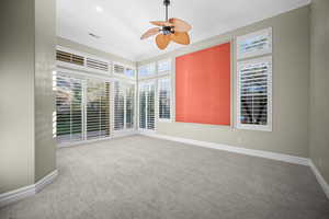 Carpeted spare room with ornamental molding and a ceiling fan