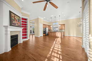 Unfurnished living room with a tile fireplace, crown molding, ceiling fan, light wood-style flooring, and recessed lighting