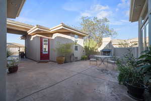 View of patio featuring an outdoor fireplace and a gate