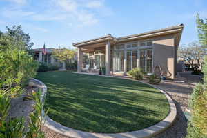 Rear view of house with a patio, stucco siding, and a lawn