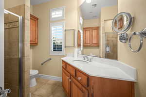 Bathroom with vanity, a stall shower, and light tile patterned floors
