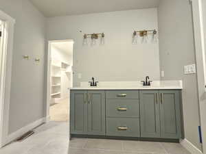Full bathroom featuring double vanity and light tile patterned floors