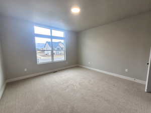 Unfurnished room with carpet and a textured ceiling