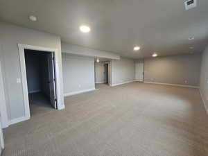 Empty room with recessed lighting, light colored carpet, and a smoke detector