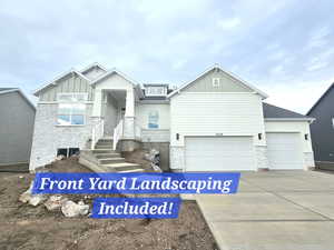 View of front of property featuring board and batten siding, stone siding, and driveway