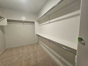 Walk in closet with light carpet
