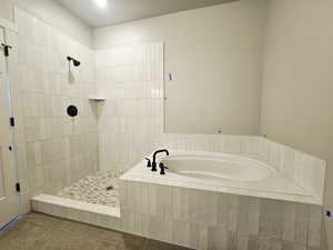 Full bathroom featuring a bath, a tile shower, and tile patterned floors