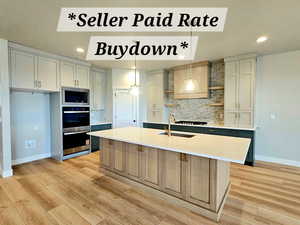 Kitchen featuring pendant lighting, a kitchen island with sink, stainless steel appliances, light wood-style flooring, and open shelves
