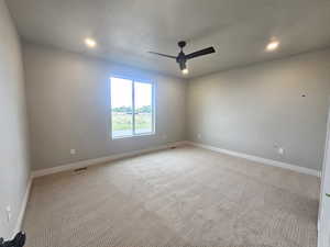 Empty room featuring carpet, a ceiling fan, and recessed lighting