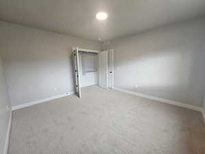 Unfurnished bedroom featuring baseboards and carpet