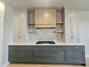 Kitchen featuring open shelves, tasteful backsplash, and light wood-style flooring