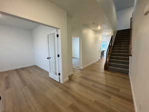 Hallway with stairway and light wood-type flooring