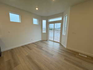 Spare room with healthy amount of natural light, light wood-type flooring, and recessed lighting