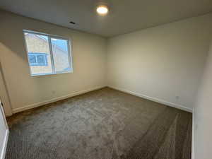Empty room featuring carpet and baseboards