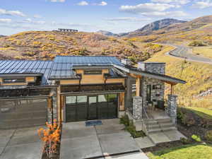 Contemporary home featuring a standing seam roof, a mountain view, a metal roof, and stone siding