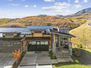 View of front of home featuring a standing seam roof, a metal roof, and driveway
