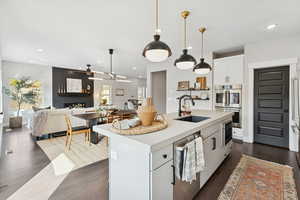 Kitchen with white cabinets, open floor plan, dark wood finished floors, appliances with stainless steel finishes, and recessed lighting