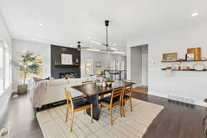 Dining room with recessed lighting, a large fireplace, dark wood-style flooring, and ceiling fan