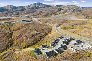 Aerial view of property and surrounding area with a mountain backdrop