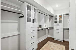 Spacious closet with dark wood-type flooring