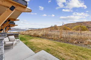 View of grassy yard with a patio area and a mountain view