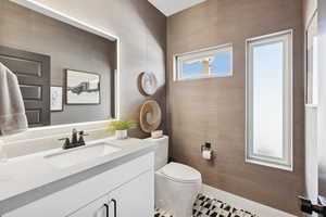 Bathroom with vanity and wallpapered walls