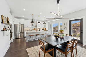 Dining room with dark wood-type flooring, recessed lighting, and a chandelier