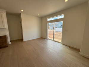 Unfurnished dining area with recessed lighting, light wood-type flooring, and a textured ceiling
