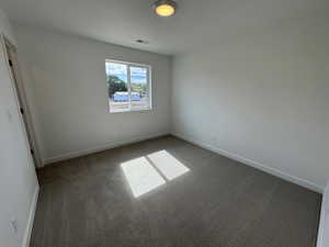 Spare room featuring carpet and baseboards