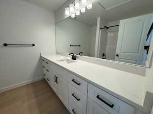 Full bathroom featuring light wood-style flooring, vanity, and a shower