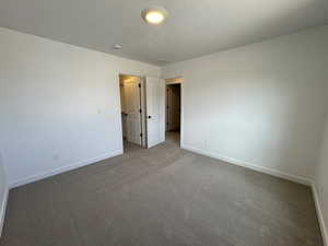 Unfurnished bedroom with carpet and a textured ceiling