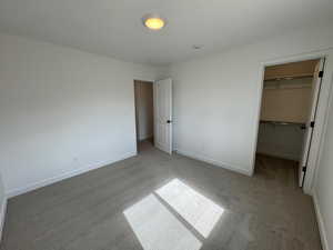 Unfurnished bedroom with carpet and a spacious closet
